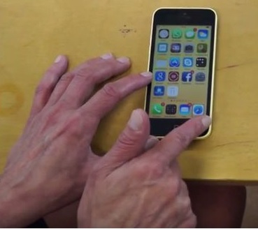 Älypuhelin kosketusnäytöllä, käyttäjän sormet ihan kosketusnäytön alalaidassa.